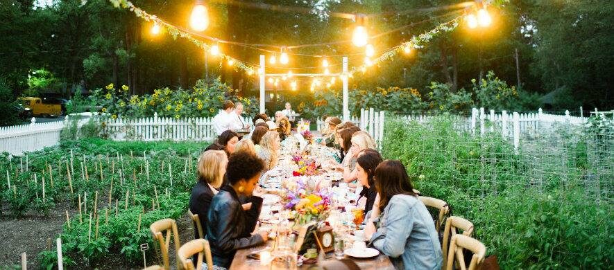 Communal dinner table in a productive garden at dusk